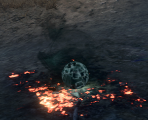 A glowing black-grey ball lies on the ground, surrounded by smoke.
